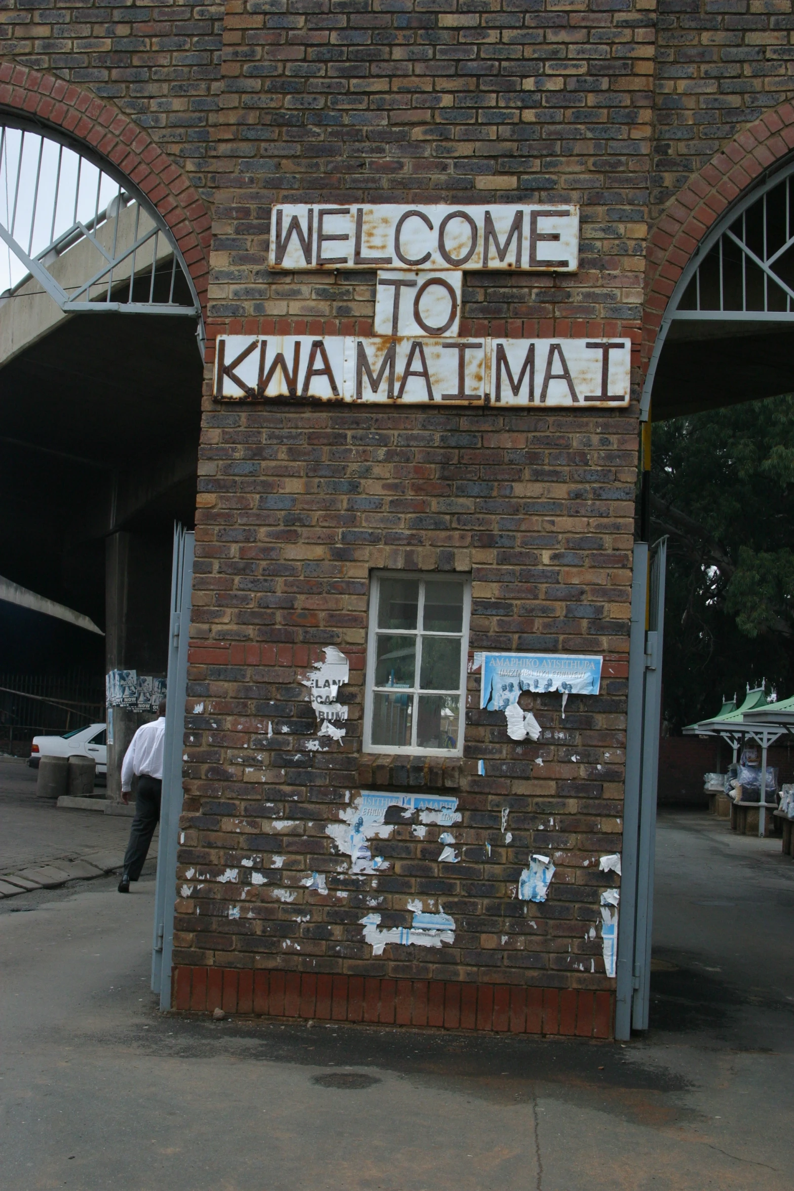 a brick building with an arched window and a welcome sign above it