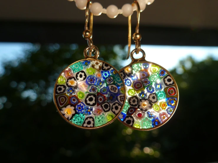 a pair of multicolored earrings hanging from a necklace