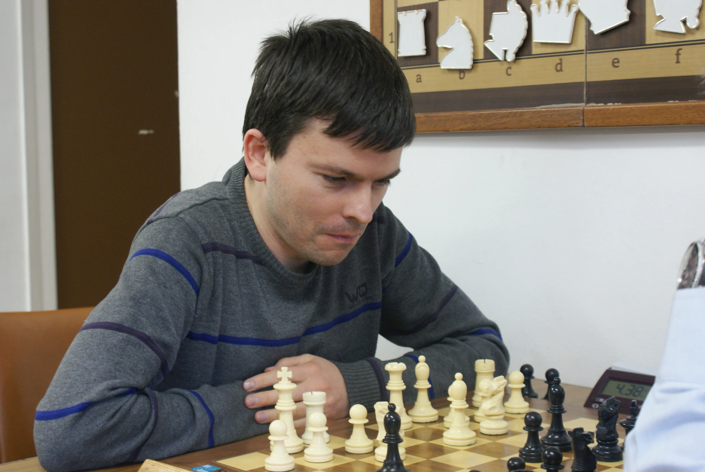 a man playing chess in front of a large piece