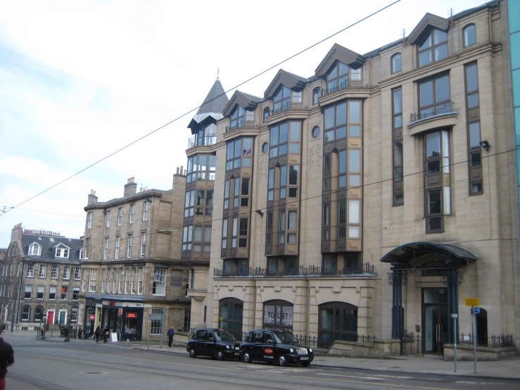 a large building is on the corner by some buildings