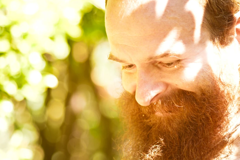 a man with long beard and red hair looking over his shoulder