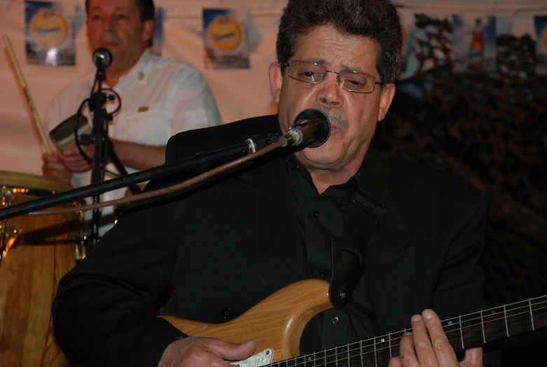 a man with glasses plays an acoustic guitar