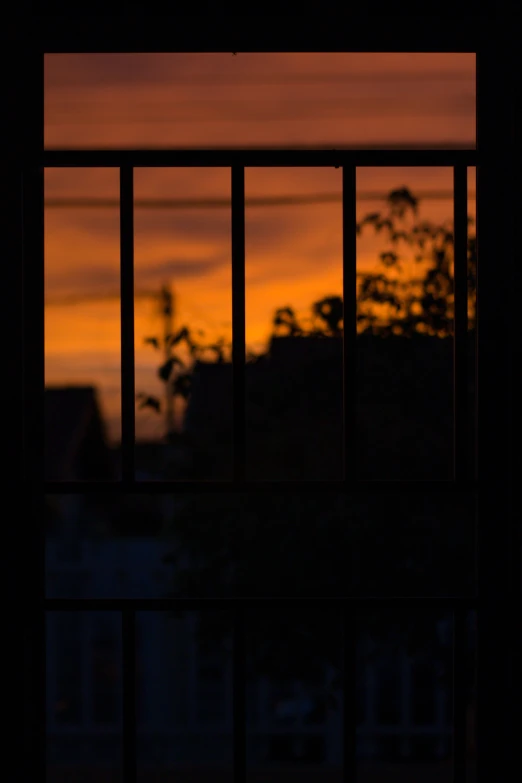 a view of a sunset from a window at the same time as the sun is setting