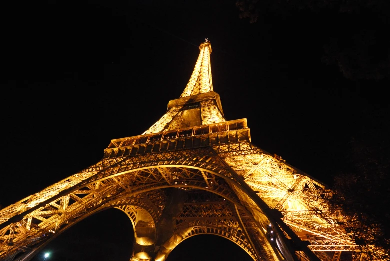 the eiffel tower is glowing bright at night