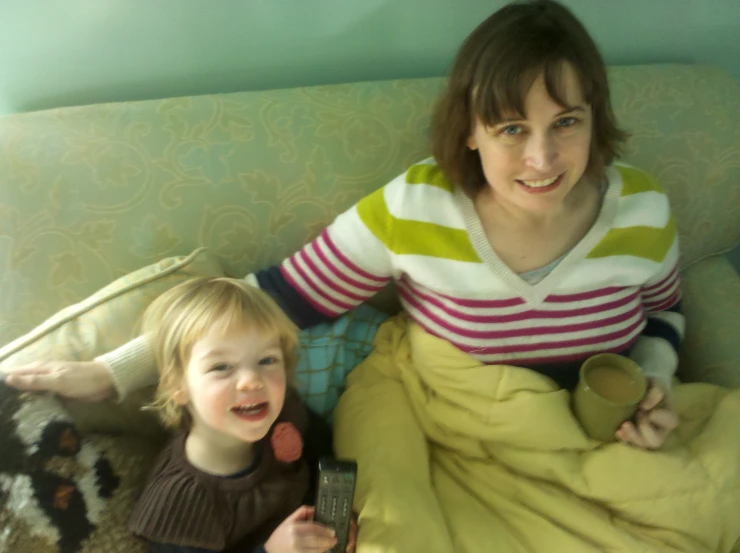 a woman and small child sit in a green chair