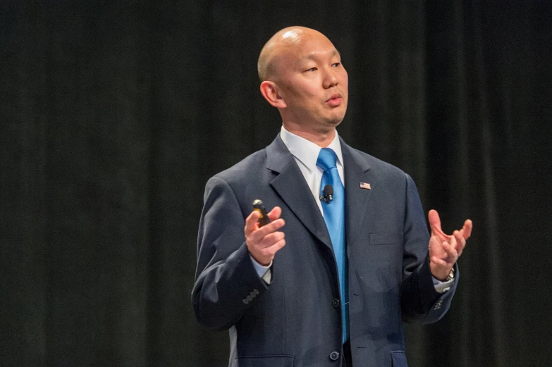 man wearing a blue tie giving a presentation