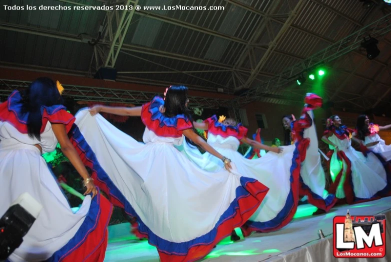 a group of women in colorful dress dancing on stage