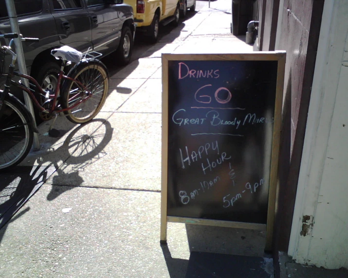 a chalkboard menu outside of a bar