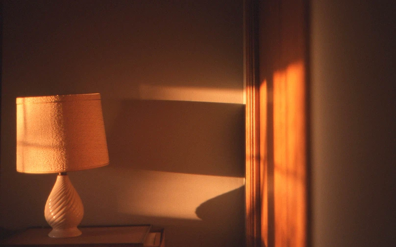 a lamp in the corner is reflected on the wall