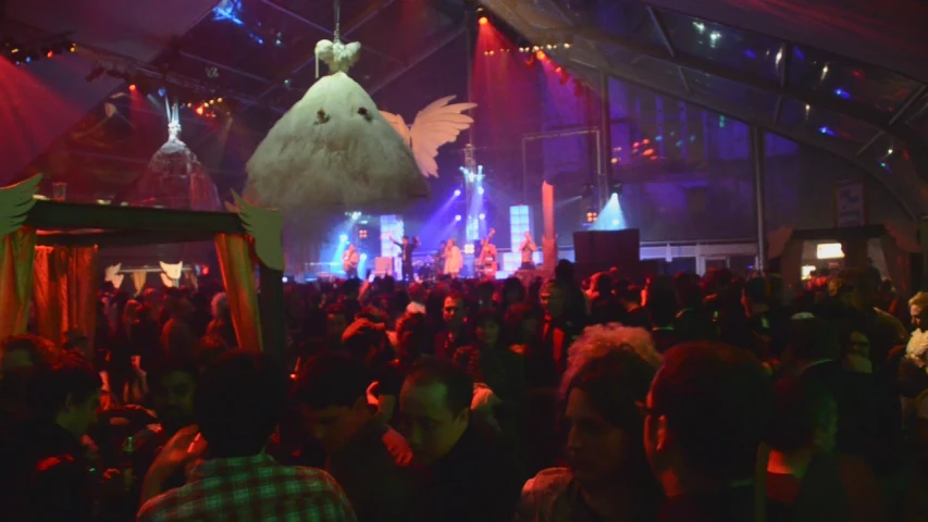 crowd of people in front of a decorated bird over head in an indoor concert hall