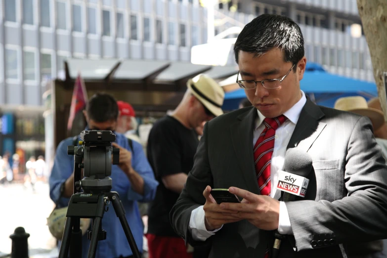 a man with glasses is using his cellphone