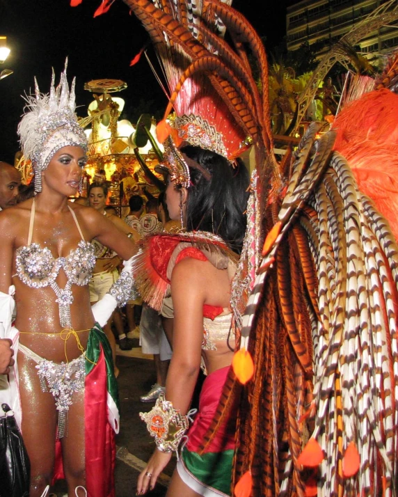 a couple of women in very elaborate costumes standing in the street