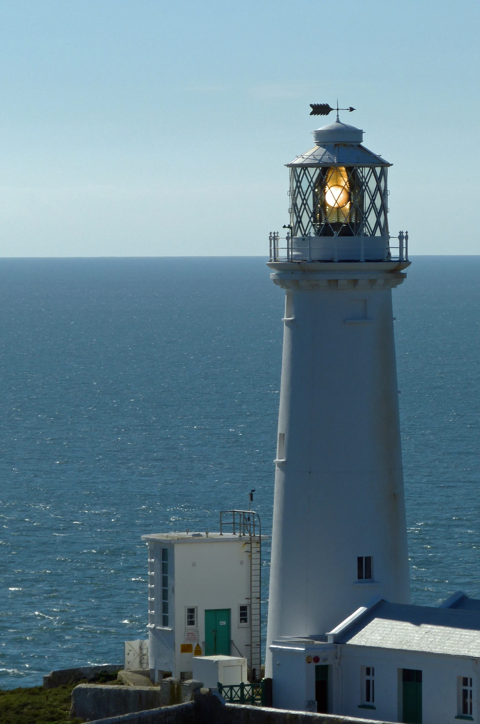 a lighthouse on a rock out in the ocean