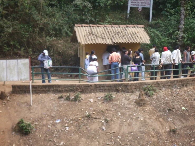 several people stand outside in line at a park