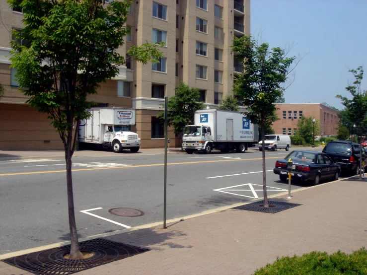 a city street lined with parking meters and delivery trucks