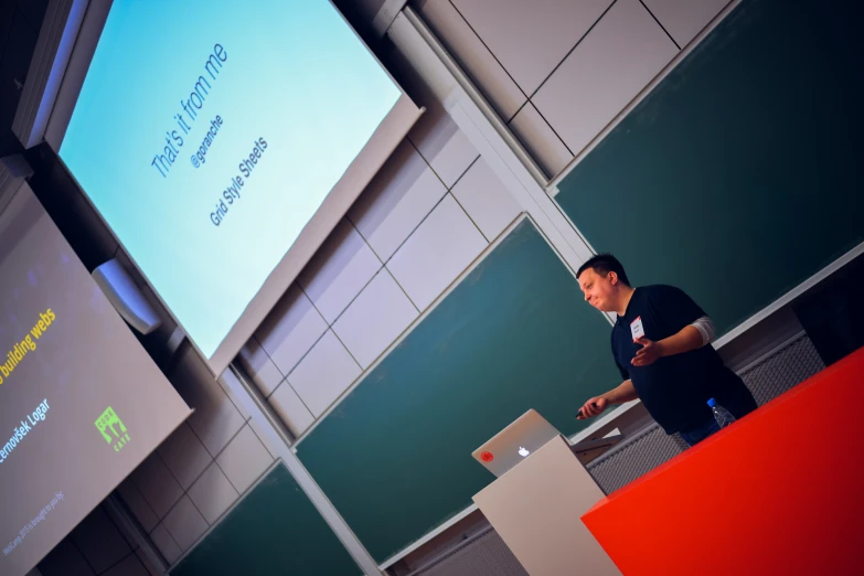 an asian man standing behind a podium giving a presentation