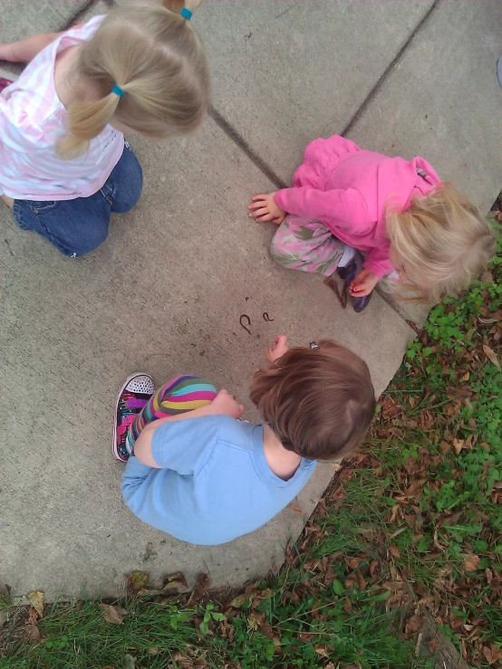 two children playing with a frisbee on the ground