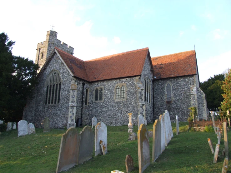 a stone church building with a brown roof and tall spire