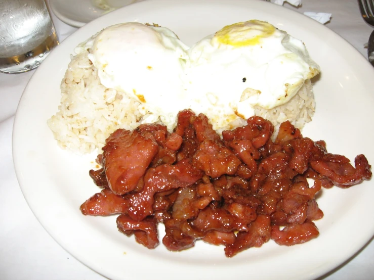 a plate with meat and rice and a fried egg