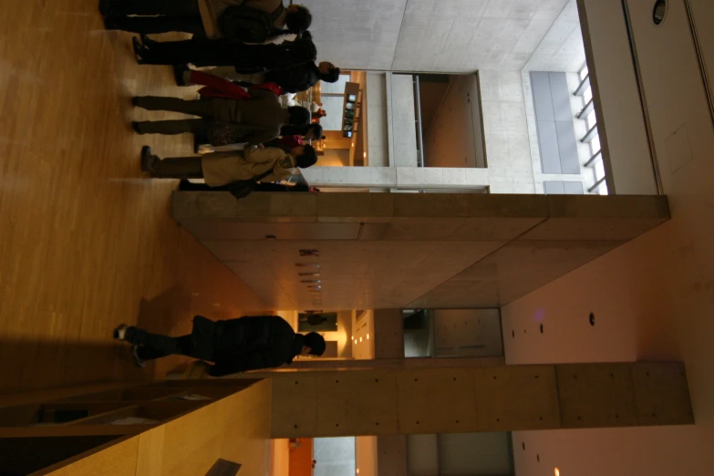a group of people standing around inside of a building