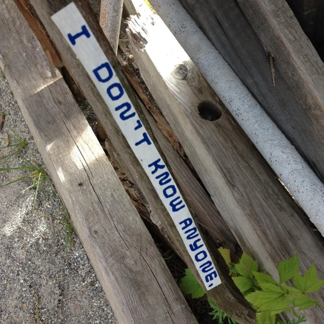 a wooden fence holding wood pieces with writing on them