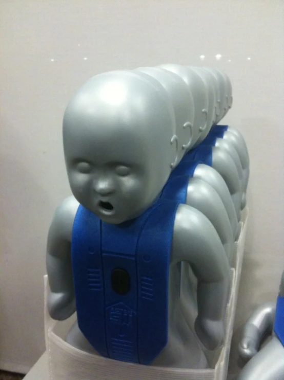 a sculpture of an individual has a blue harness on
