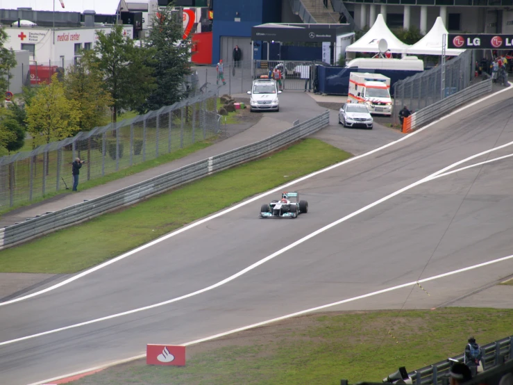 some cars racing on a track near spectators