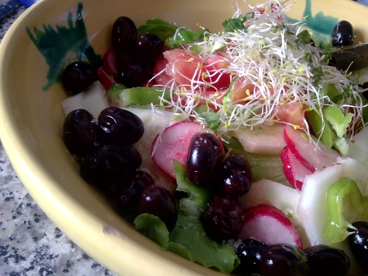 gs, cherries, and celery sit in a yellow bowl