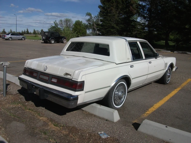 a white cadillac parked in a parking lot