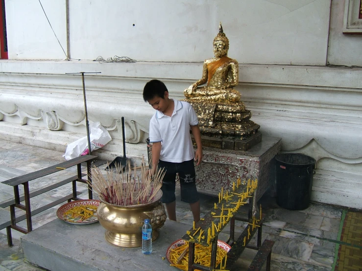 a young man standing next to an elaborately decorated temple