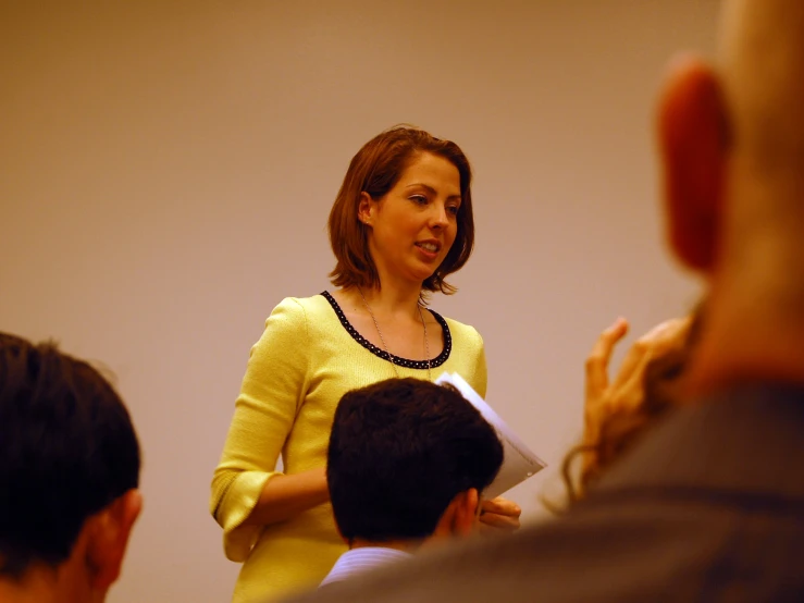 a woman is making a presentation and people are looking on