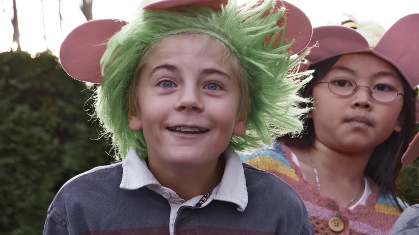 two children wearing green hair with their ears