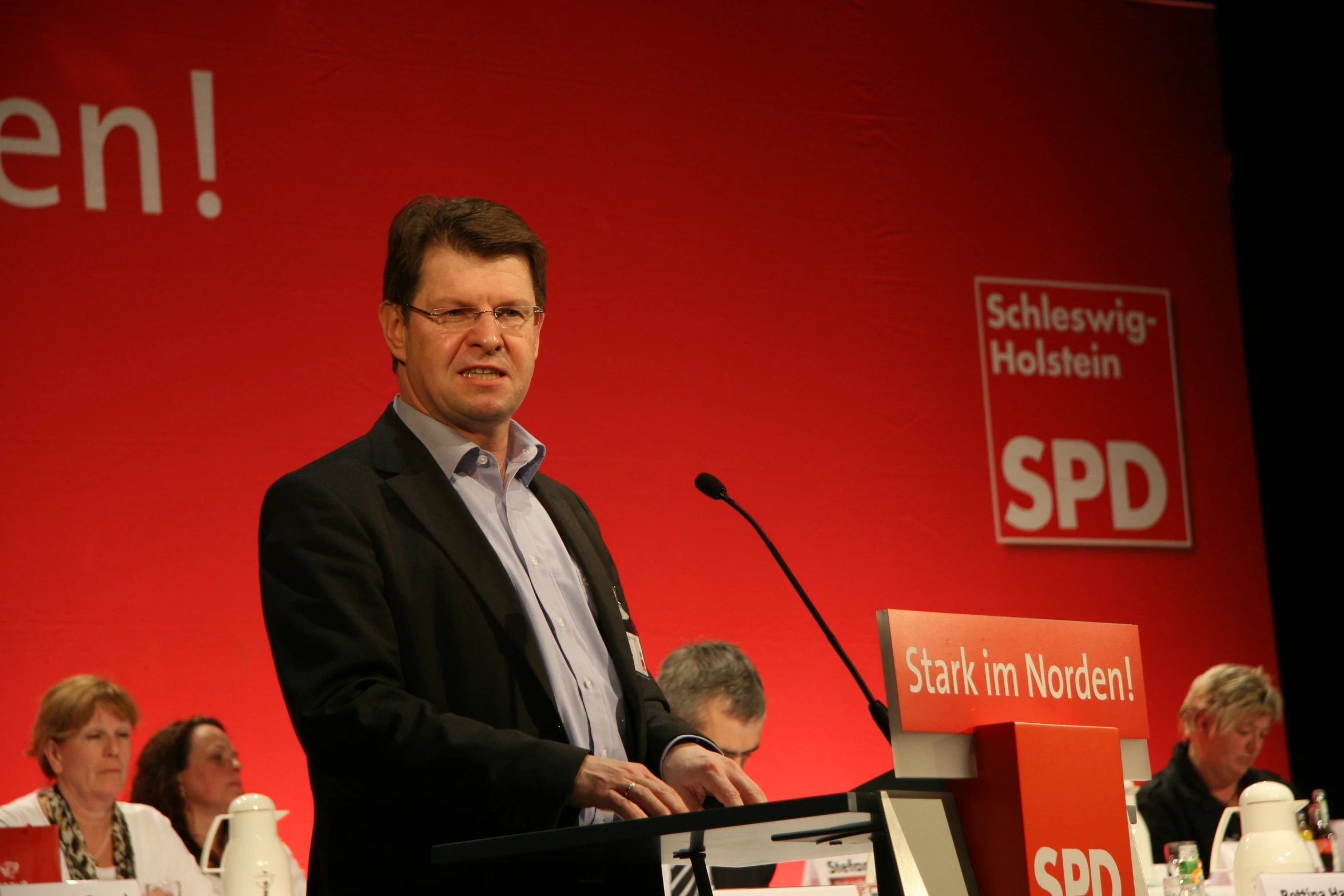 a man standing behind a podium at a conference