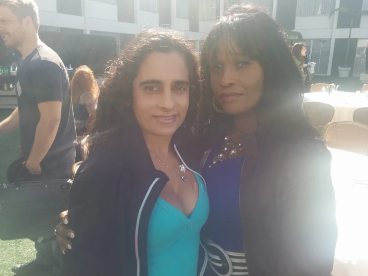 two women posing for the camera outdoors