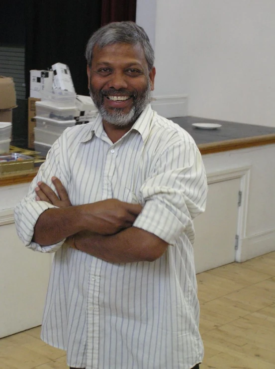 a smiling man wearing a shirt in a hospital room