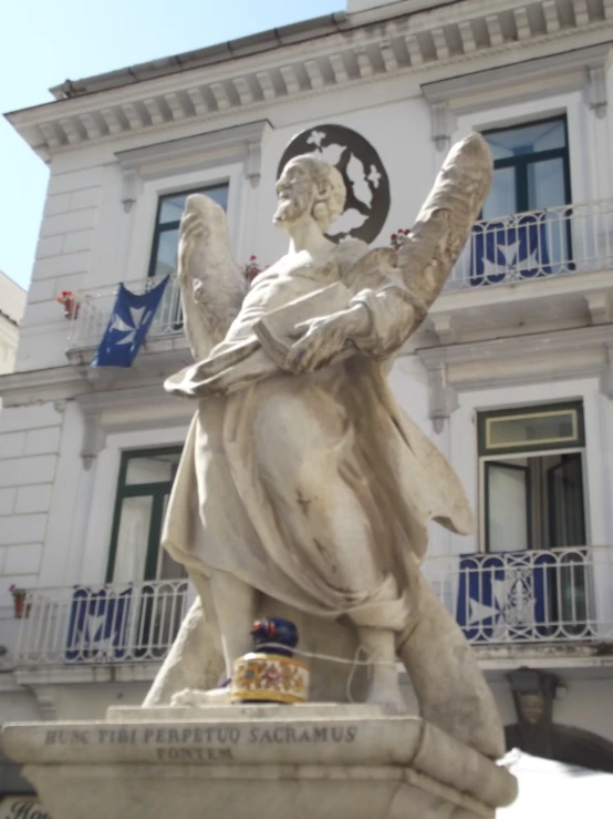 the large white statue is holding an earth globe