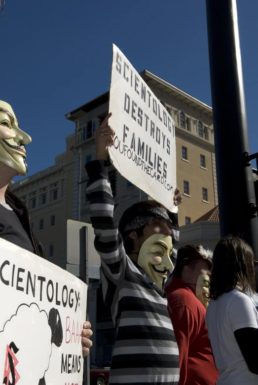 some people holding signs in a protest against fraging and racism