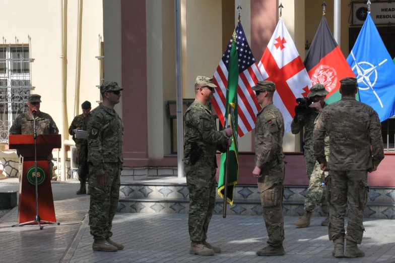 a couple of soldiers are talking in front of flags