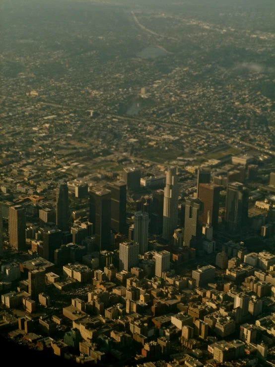 the view from a jet shows large buildings on a city