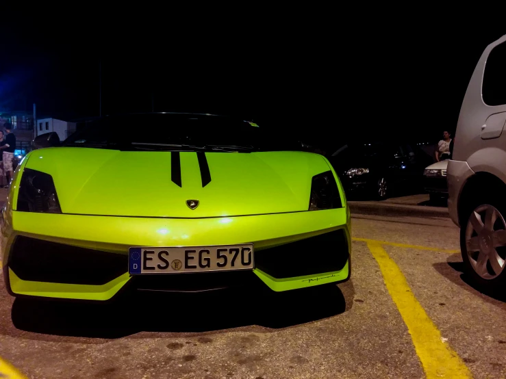 a car parked in a parking lot with a lot of people around it