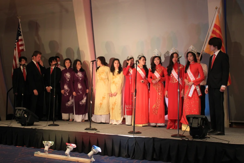 a crowd of people standing next to each other on top of a stage