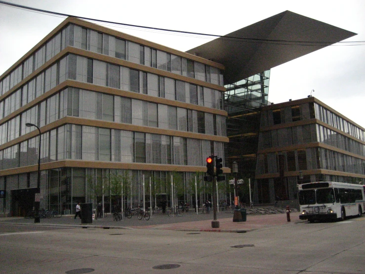 a city bus is stopped outside of a tall building