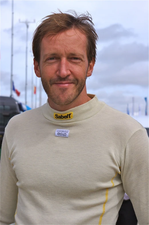 a man smiling in a yellow and black shirt