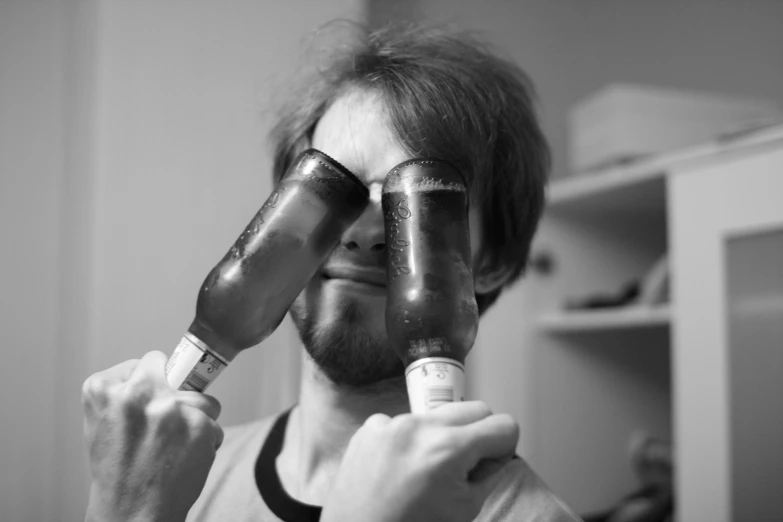 man looking through two tape shaped glasses in black and white