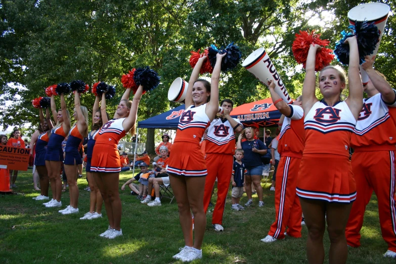 some cheerleaders with large hats doing different things