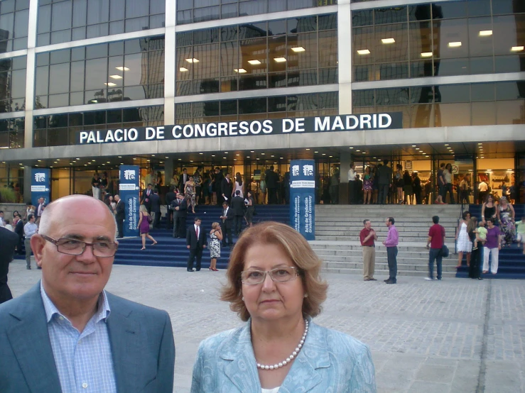 the couple poses for a picture outside the convention center