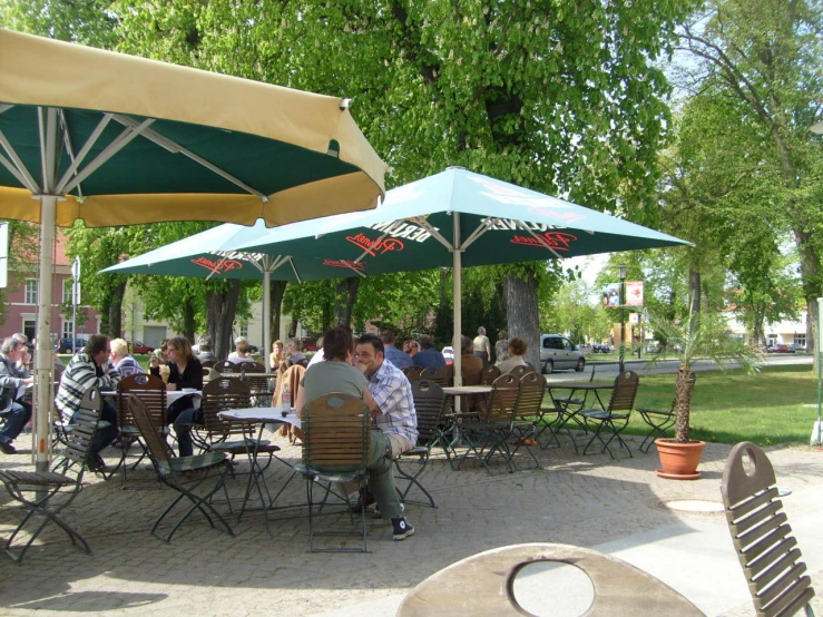 a group of people sitting under umbrellas outside