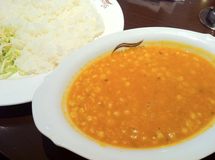 a bowl of soup and a plate with rice