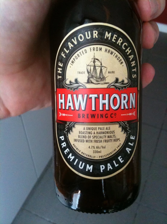 a man holding a bottle of beer that says hawthorn brewing
