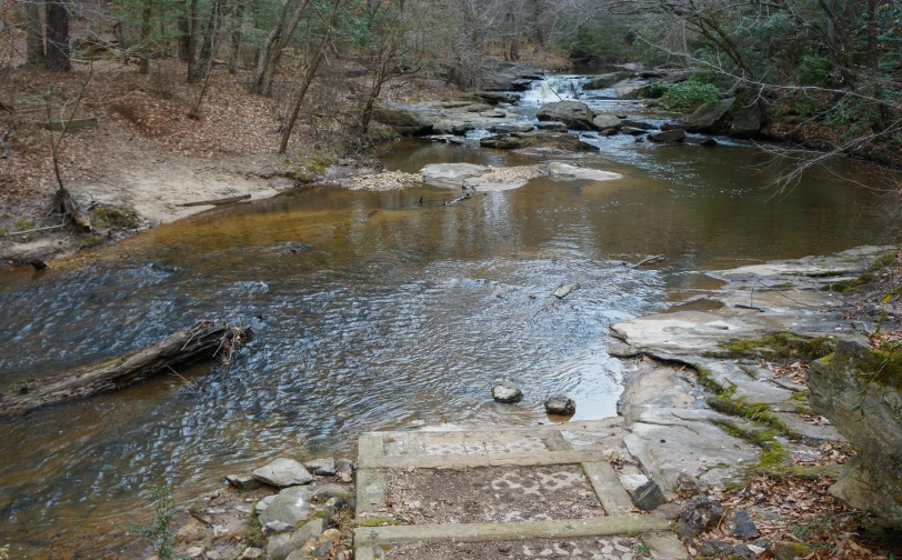 there is a small stream with some steps leading it